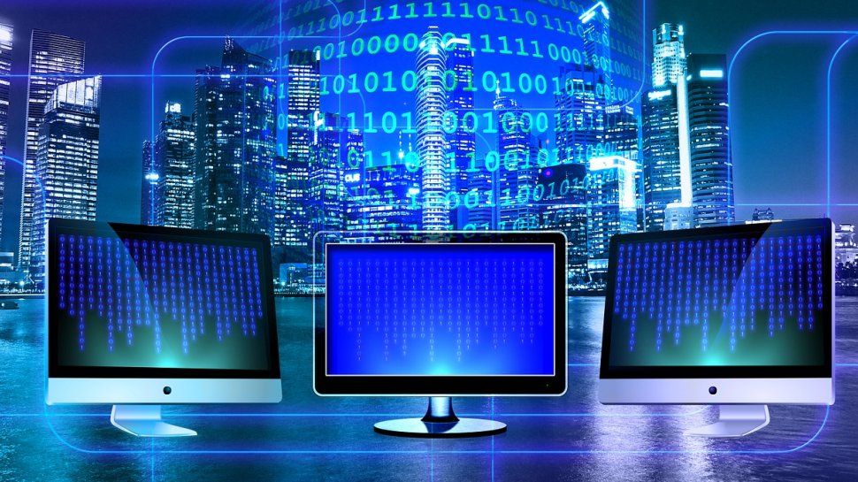 Three computer monitors against a blue digital background.