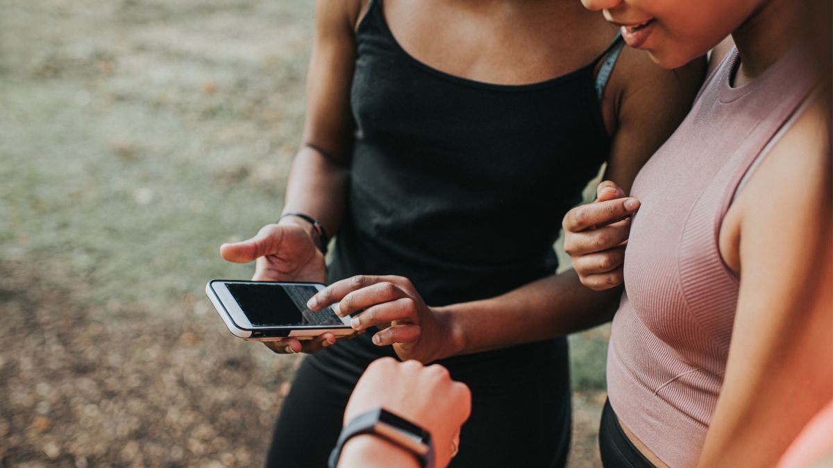 Image of three women checking a fitness tracker and app