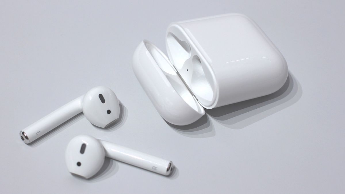 A pair of airpods with their charging case