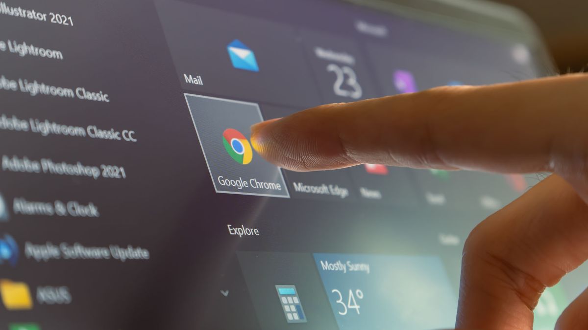 A finger touching the google chrome icon in the Windows 10 start menu