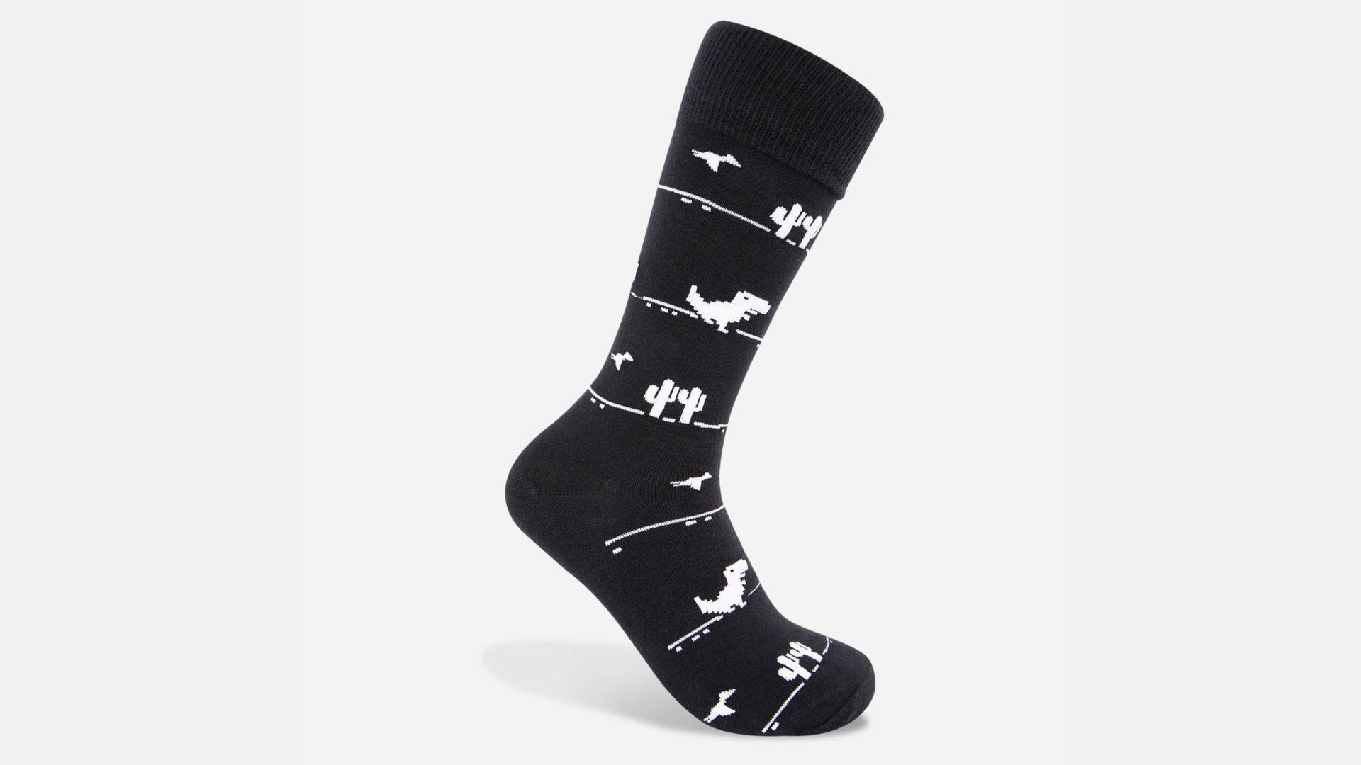 Black socks with the Chrome Dino in white running through a white desert full of cacti and bird