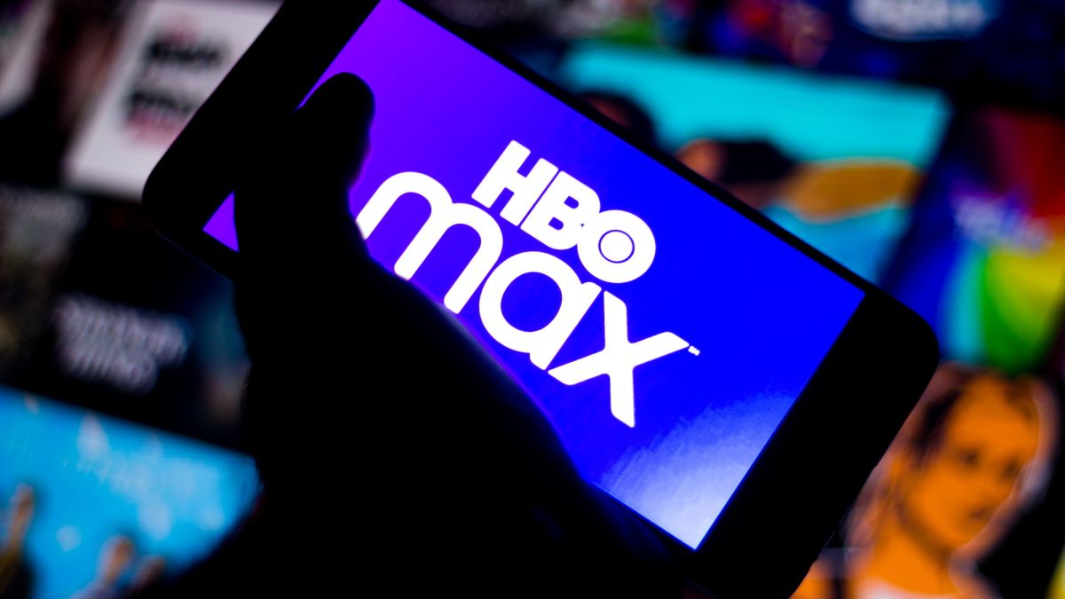A stock image of the HBO Max logo on a smartphone held by a hand