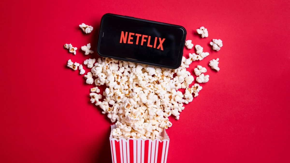 Netflix on a smartphone dropped in a bucket of popcorn