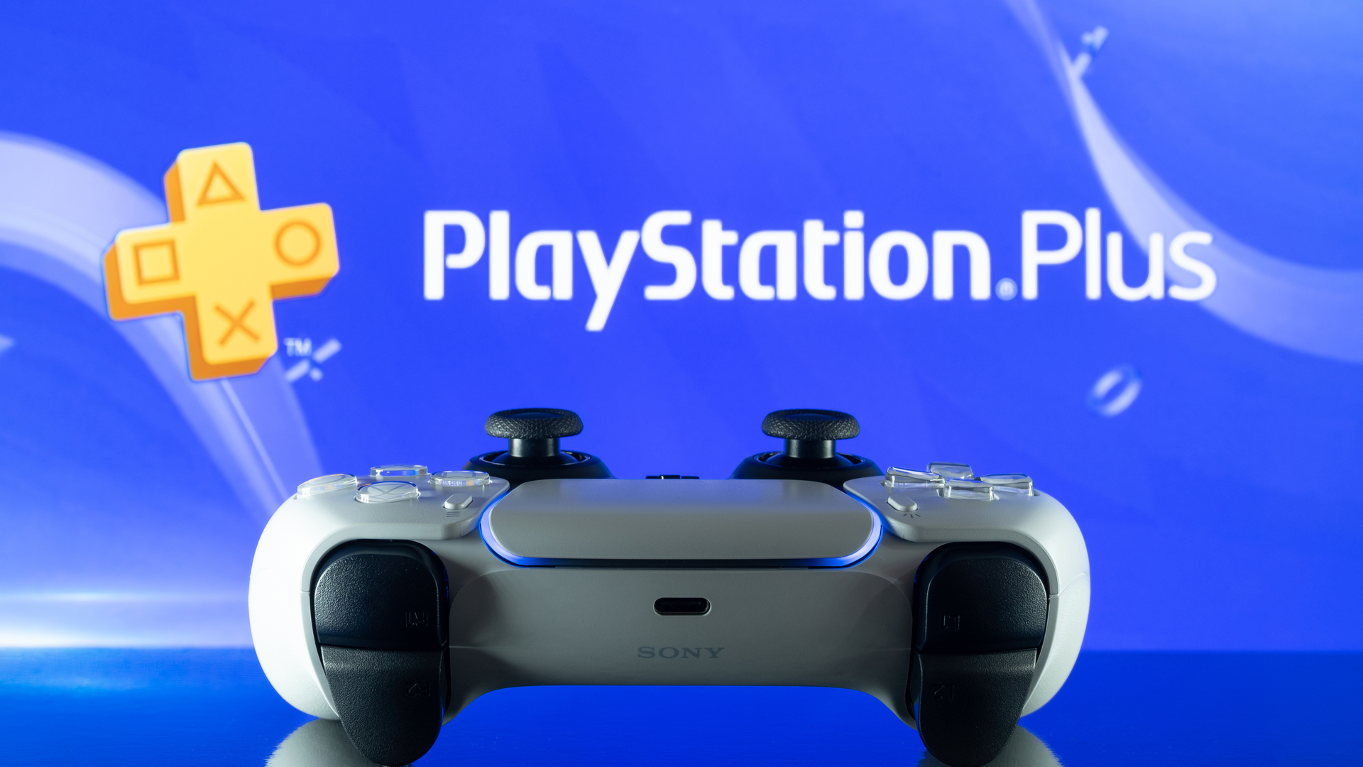 DualSense PS5 controller in front of the PlayStation Plus logo