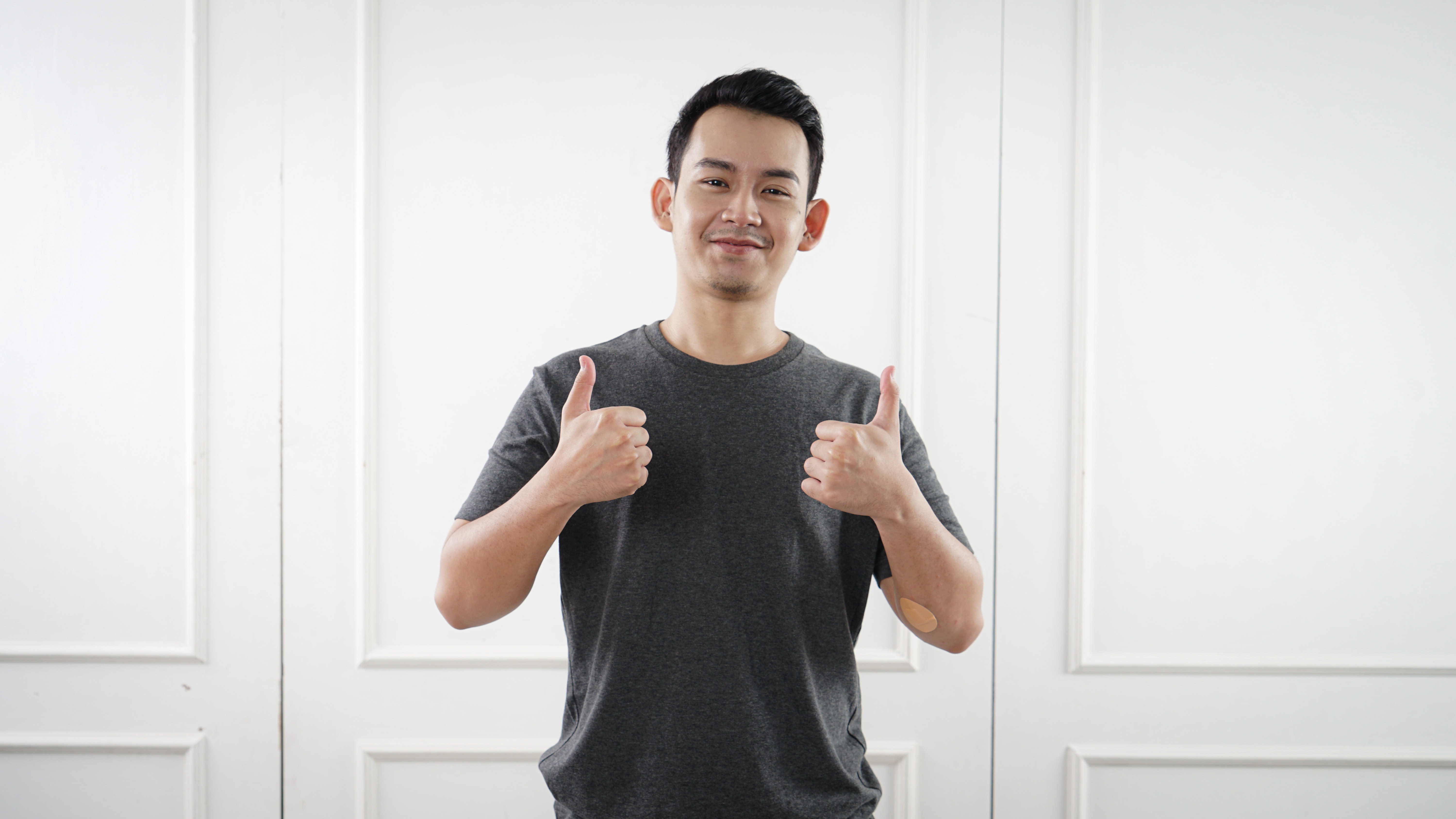 Man giving two thumbs up with a white background