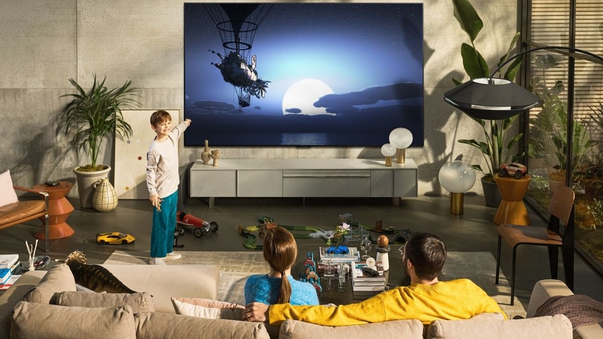 LG 97G2 in a living room, with a boy pointing at the screen
