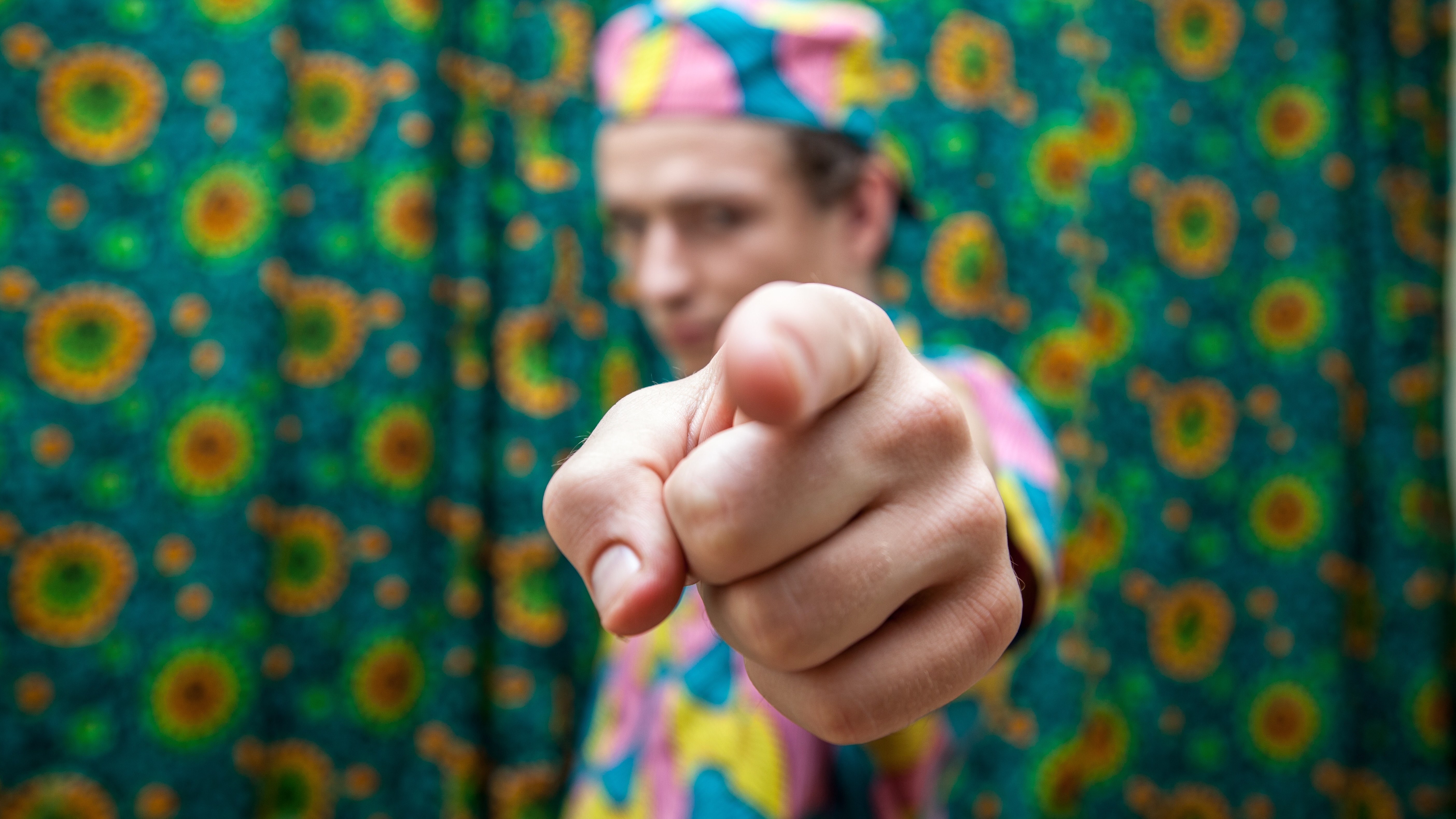 a person in colorful clothing pointing the finger at you.