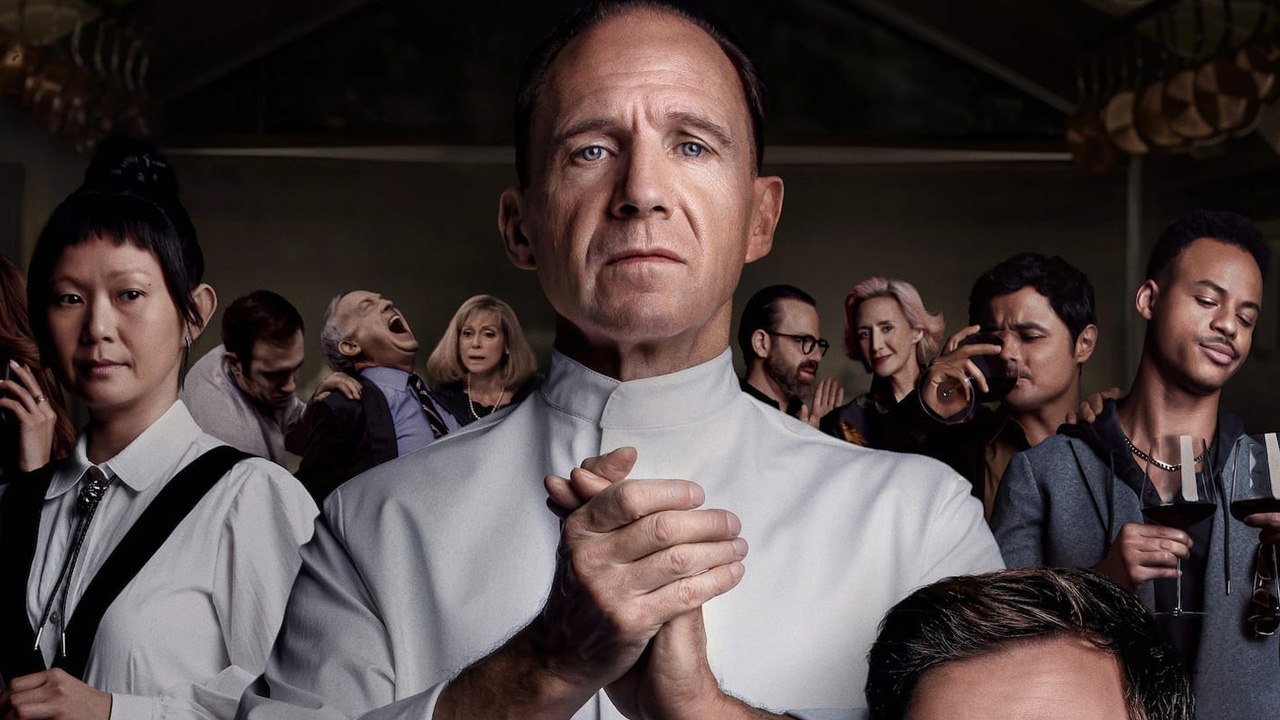 A promotional image for The Menu, with Ralph Fiennes' Chef Slowik from and center