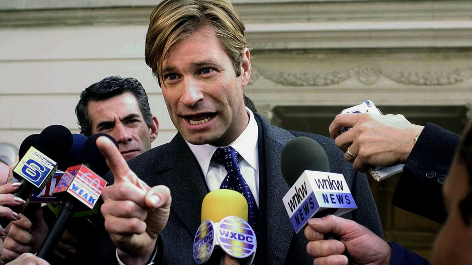 A still from the movie Thank You For Smoking in which Aaron Eckhart talks into microphones