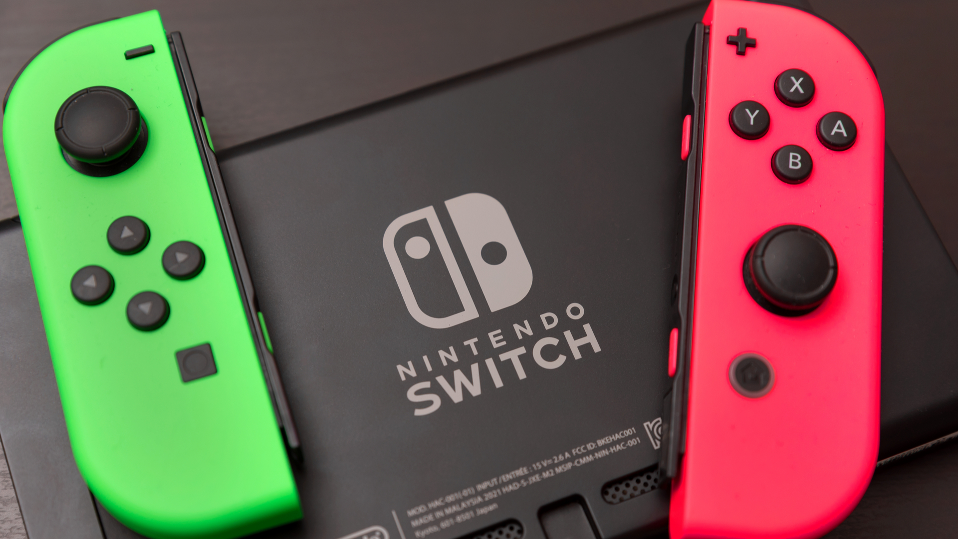 Green and pink Joy-Con sitting on top of the back of Switch