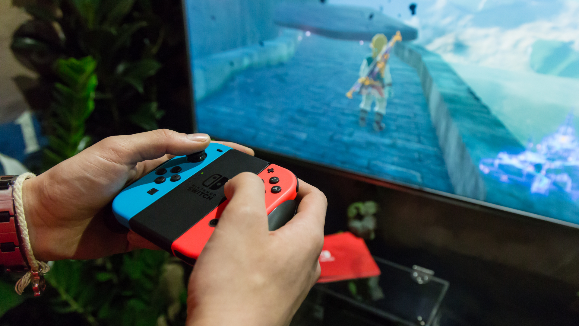 A Nintendo Switch player using the Joy-Con controllers to play Breath of the Wild on a TV