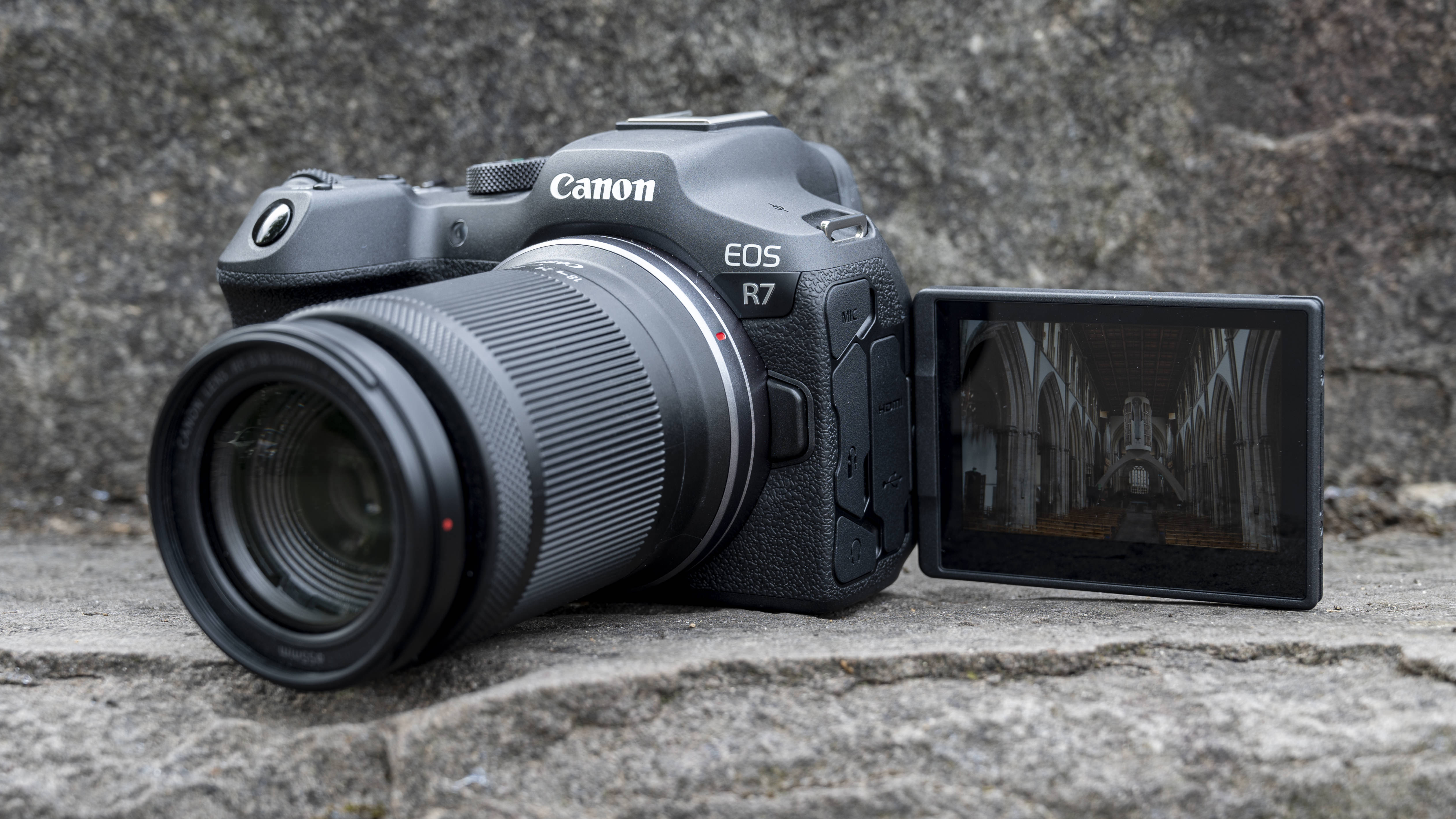 The Canon EOS R7 camera sitting on a stone step